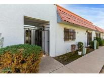 Exterior view of a well-maintained townhouse featuring a gated entry and stucco facade at 6812 N 35Th Ave # G, Phoenix, AZ 85017