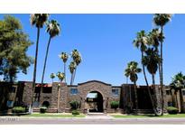 Charming apartment complex featuring desert landscaping with palm trees against a backdrop of clear blue skies at 7110 E Continental Dr # 1031, Scottsdale, AZ 85257