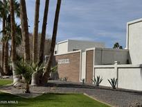 Landscaped community entrance with modern architecture and mature palm trees at 8588 E Indian School Rd # G, Scottsdale, AZ 85251