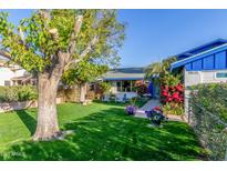 Charming home with a lush, green lawn, beautiful flowers, and inviting curb appeal at 8626 E San Miguel E Ave, Scottsdale, AZ 85250