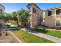 Charming two-story townhome with mature trees, green grass and well maintained landscaping at 910 W Aspen Way, Gilbert, AZ 85233