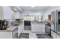 Bright kitchen with modern appliances, light gray counters, and a view into the open-plan living area at 9115 W Kimberly Way, Peoria, AZ 85382