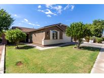 Charming single-story home with a well-manicured lawn and appealing curb appeal on a sunny day at 119 W Leatherwood Ave, San Tan Valley, AZ 85140