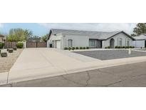 View of home's driveway, landscaping and gray exterior at 11942 N 95Th St, Scottsdale, AZ 85260