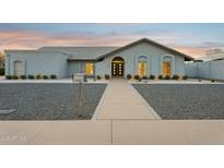 Charming single-story home with gray gravel landscaping and an inviting walkway to the front door at 11942 N 95Th St, Scottsdale, AZ 85260