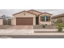 Charming single-story home featuring a two-car garage, desert landscaping, and a welcoming facade at 18625 W Williams Rd, Surprise, AZ 85387