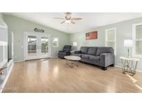 Bright living room features a neutral palette, ceiling fan, and sliding glass doors to the backyard at 2129 N Apollo Ct, Chandler, AZ 85224