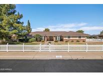 Charming single-story home with a welcoming front yard and white picket fence at 3160 E Fox St, Mesa, AZ 85213