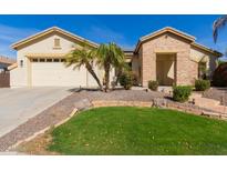 Charming single-story home featuring desert landscaping, a green lawn, and a two-car garage at 450 E Alamosa Dr, Chandler, AZ 85249