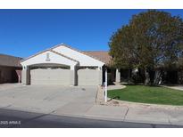 Charming single-story home featuring a well-maintained front yard and a three-car garage at 5624 E Garnet Ave, Mesa, AZ 85206