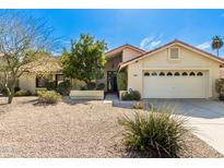 Charming single-story home with desert landscaping, two-car garage, and a red tile roof in a sunny neighborhood at 817 E Meadow Ln, Phoenix, AZ 85022