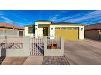 Charming single-story home featuring a well-manicured front yard, decorative fence, and a yellow two-car garage at 1625 S 113Th Ave, Avondale, AZ 85323