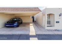 Attached carport featuring a blue car and access to the home's entrance with well-maintained exterior and landscaping at 1651 E Borghese Pl, Phoenix, AZ 85016