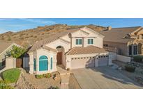 Charming home featuring a tile roof, three-car garage, and professionally landscaped front yard with desert surroundings at 16825 S 12Th Way, Phoenix, AZ 85048