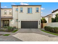 A modern home with a large garage and a well-maintained paver driveway at 1929 S Follett Way, Gilbert, AZ 85295