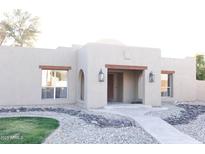 Charming Southwestern-style home featuring desert landscaping, a covered entry, and decorative wooden accents at 2113 E Glencove St, Mesa, AZ 85213