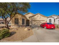 Charming single-story home with a two-car garage and mature landscaping, complemented by a red car in the driveway at 26826 N 66Th Ln, Phoenix, AZ 85083