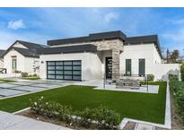 Modern home with a sleek design, well-manicured lawn, and striking stone accents at 4219 N 41St Pl, Phoenix, AZ 85018