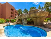 Inviting pool with rock waterfall feature offering a refreshing and unique outdoor amenity at 4303 E Cactus Rd # 408, Phoenix, AZ 85032
