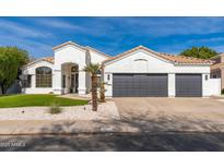 Charming single-story home with a three-car garage, desert landscaping, and a bright, welcoming facade at 5456 E Woodridge Dr, Scottsdale, AZ 85254
