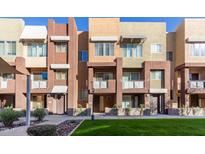 Modern townhome exterior showcases colorful facades, awning accents, and lush community landscaping at 6605 N 93Rd Ave # 1022, Glendale, AZ 85305