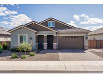 Charming single-story home featuring a well-maintained front yard and a two-car garage at 15233 W Baden St, Goodyear, AZ 85338