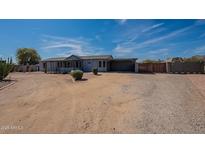 Charming single-story home featuring a large yard, carport, and desert landscaping at 1612 N 201St Ave, Buckeye, AZ 85396