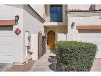 Inviting front entrance featuring an arched wood door, lush shrubbery and decorative tile at 1750 E Ocotillo Rd # 11, Phoenix, AZ 85016