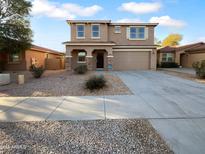 Two-story home featuring a two car garage, neutral color scheme, and desert landscaping at 17699 W Tonto St, Goodyear, AZ 85338