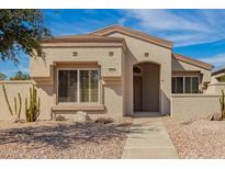 Charming single-story home with desert landscaping and neutral color palette under a sunny, blue sky at 19802 N Greenview Dr, Sun City West, AZ 85375