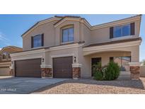 Charming two-story home featuring a three-car garage, neutral stucco, and inviting front entrance at 23407 W Ashleigh Marie Dr, Buckeye, AZ 85326