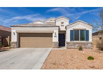 Charming single-story home with stone accents, two-car garage, and low-maintenance desert landscaping at 30940 W Indianola Ave, Buckeye, AZ 85396