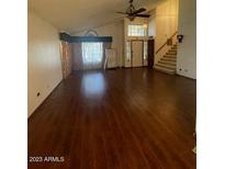 Spacious living room featuring vaulted ceilings, a ceiling fan, hardwood floors, and a bright window at 3732 N Crystal Ln, Avondale, AZ 85392