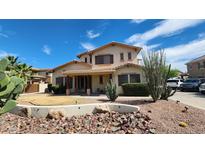 Charming two-story home with desert landscaping and a covered front porch at 4312 W Olney Ave, Laveen, AZ 85339