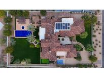 Stunning aerial view of an estate with a pool, tile roof, solar panels, and meticulously landscaped grounds at 5016 E Butler Dr, Paradise Valley, AZ 85253