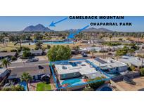 Stunning aerial view of a home near Chaparral Park, featuring a sparkling pool and lush landscaping with mountain views at 5401 N 81St Pl, Scottsdale, AZ 85250