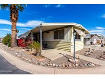Well-maintained mobile home featuring desert landscaping with a quaint covered patio, perfect for outdoor living at 11411 N 91St Ave # 48, Peoria, AZ 85345
