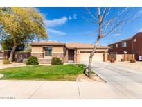Charming single-story home with a well-maintained lawn, stone accents, and a two-car garage at 15590 W Montecito Ave, Goodyear, AZ 85395