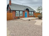 Charming brick home featuring a bright blue front door and low-maintenance desert landscaping at 1953 W Granada Rd, Phoenix, AZ 85009