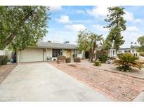 Charming home featuring a spacious driveway, two-car garage, beautiful landscaping, and a welcoming front entryway at 4308 E Montecito Ave, Phoenix, AZ 85018