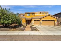 Stunning two-story home featuring a three car garage and lush front yard landscaping at 5032 W Yearling Rd, Phoenix, AZ 85083