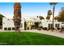 Stunning exterior view of the house featuring a manicured lawn and decorative palm trees at 5532 E Crocus Dr, Scottsdale, AZ 85254