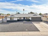 Charming single-story home featuring a spacious front yard with desert landscaping and a two-car garage at 6123 W Karen Lee Ln, Glendale, AZ 85306