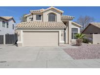 Inviting home showcasing a two-car garage, desert landscaping, and a neutral color palette at 7420 W Los Gatos Dr, Glendale, AZ 85310