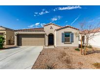 Well-maintained single-story home featuring a two-car garage, desert landscaping, and a welcoming entrance at 1018 S 5Th St, Avondale, AZ 85323