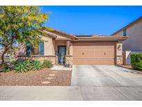 Charming single-story home featuring a desert landscape, a two-car garage, and a stone-accented facade at 14296 W Surrey Dr, Surprise, AZ 85379