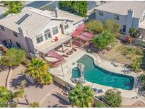 A beautiful backyard featuring a sparkling pool, spa, firepit, and an elevated deck perfect for entertaining or relaxation at 1831 W San Angelo St, Gilbert, AZ 85233