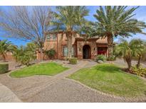 Charming two-story home with desert landscaping, palm trees, and a brick walkway leading to the arched entrance at 20396 E Via Del Rancho Rd, Queen Creek, AZ 85142