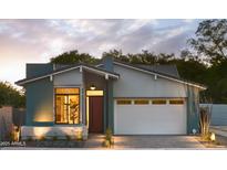 Beautiful single-story home with a red door, large window, and a white garage door and professional landscaping at 6710 N 9Th Dr, Phoenix, AZ 85013