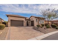 Charming home featuring a three-car garage, stone accents, arched entry, and a paved driveway at 8525 E Lynwood St, Mesa, AZ 85207